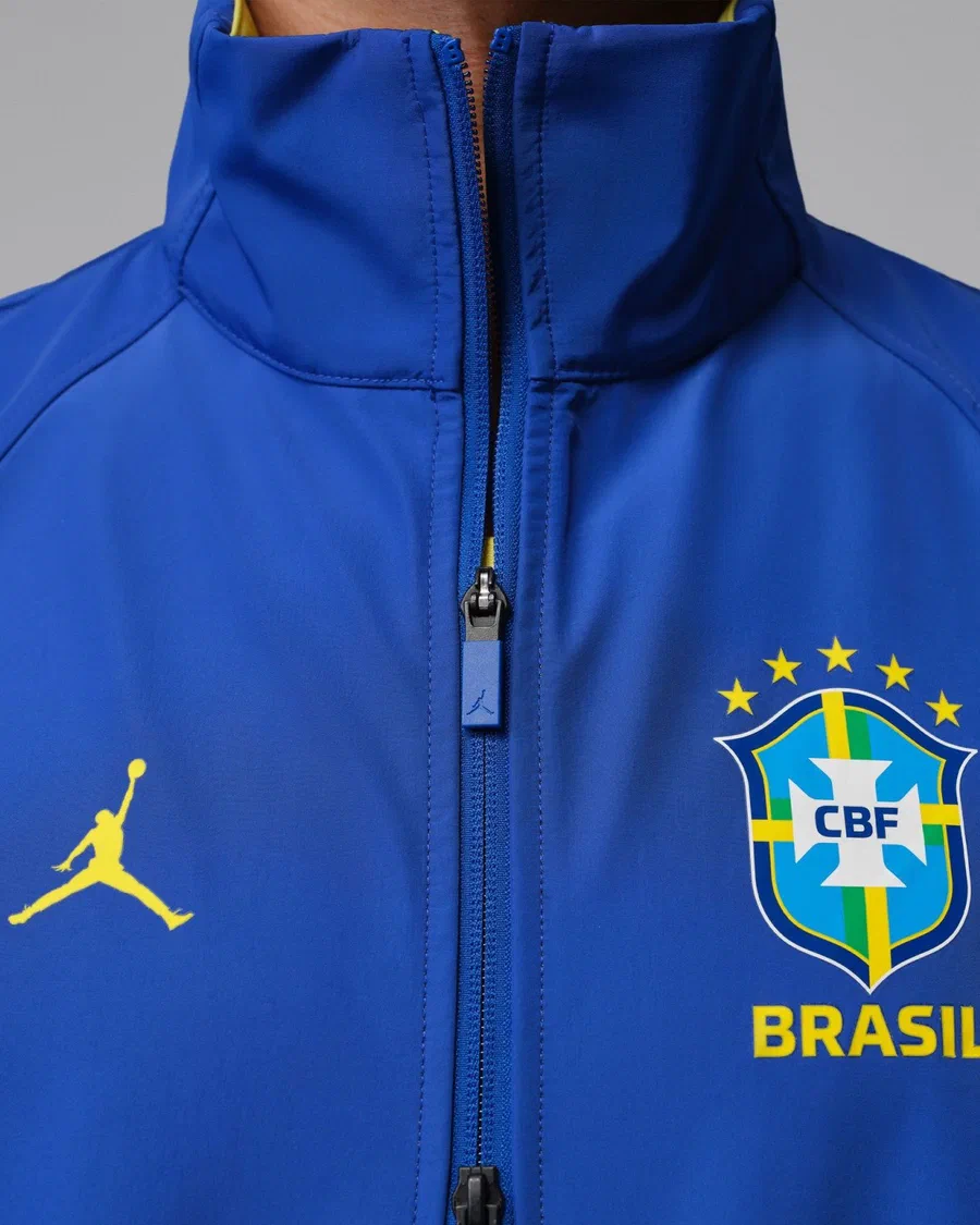 Veste Anthem Brésil Jordan bleu roi, gros plan sur le Jumpman jaune et l'écusson CBF