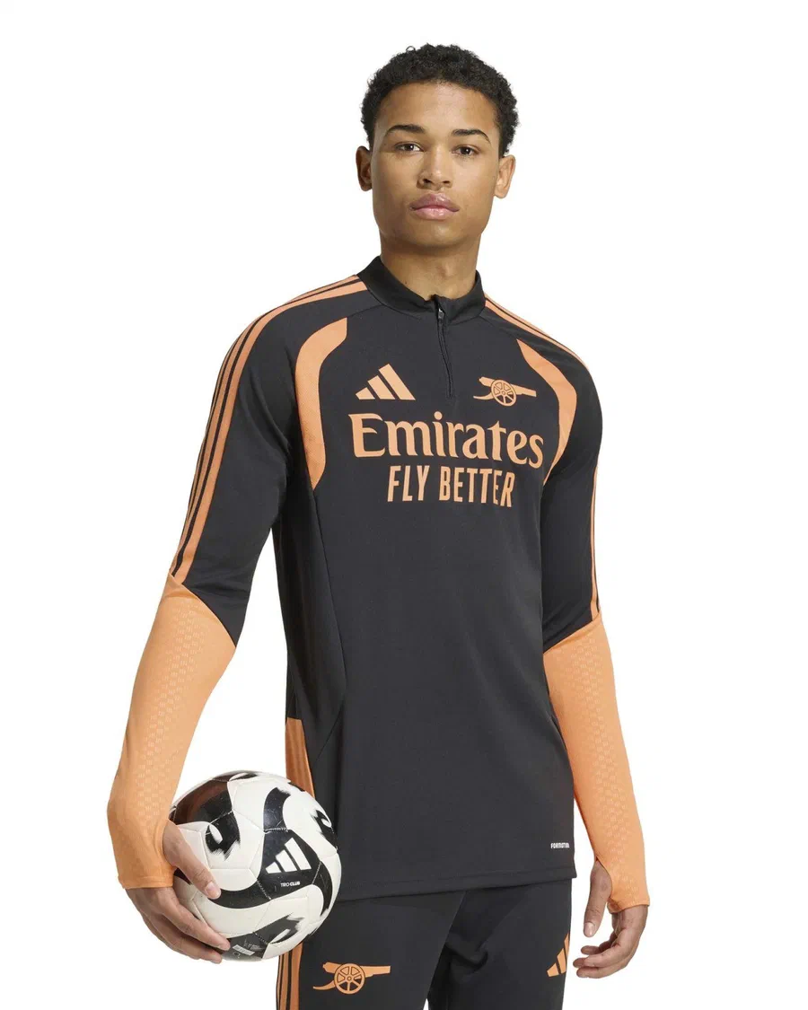 Mannequin en sweat zippé noir et orange d'Arsenal, ballon sous le bras