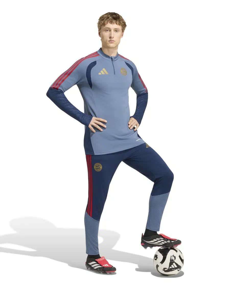 Mannequin en sweat d'entraînement bleu gris du Bayern Munich et pantalon bleu marine, pied sur un ballon