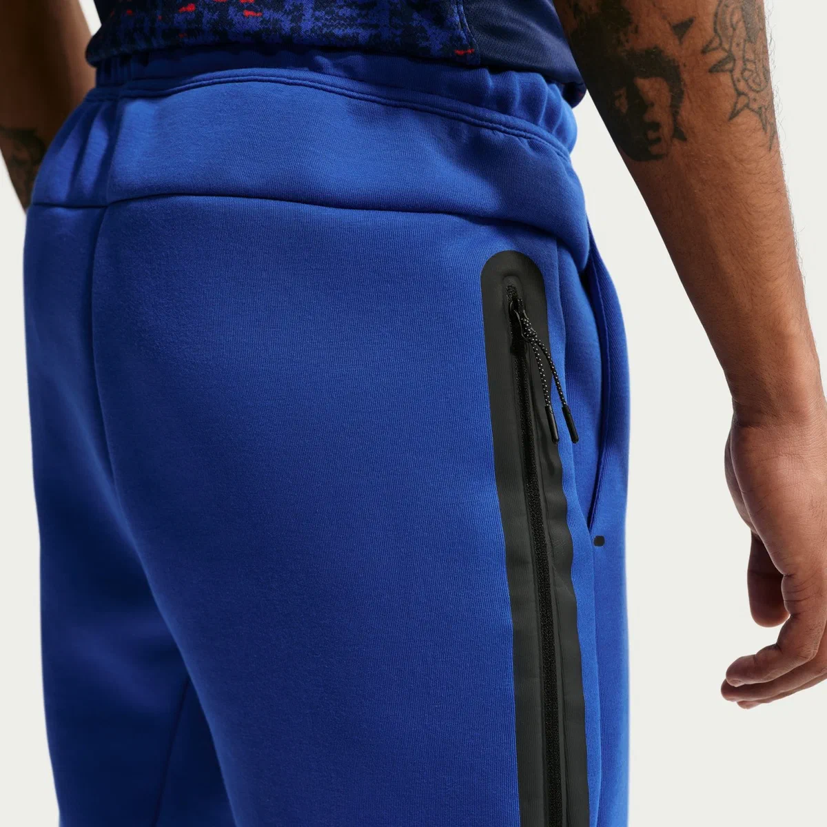 Poche zippée noire du pantalon Tech Fleece bleu