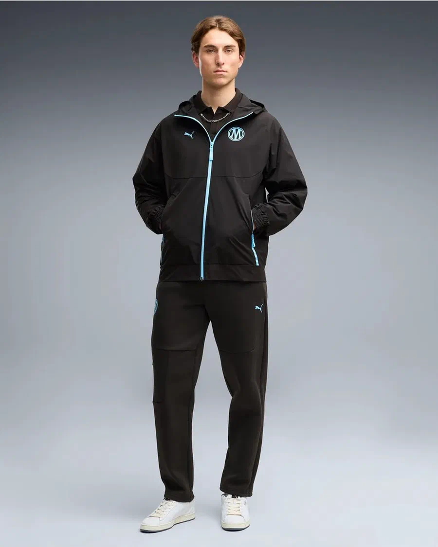 Mannequin en veste tissée PUMATECH noire de l'OM et pantalon tissé noir assorti, sur fond gris