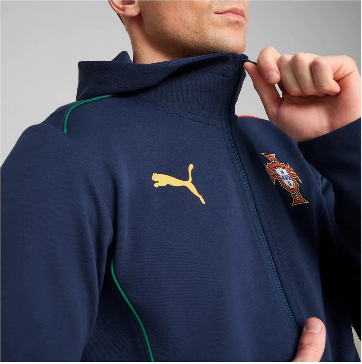 Gros plan de la veste Casuals du Portugal, logo Puma doré et écusson