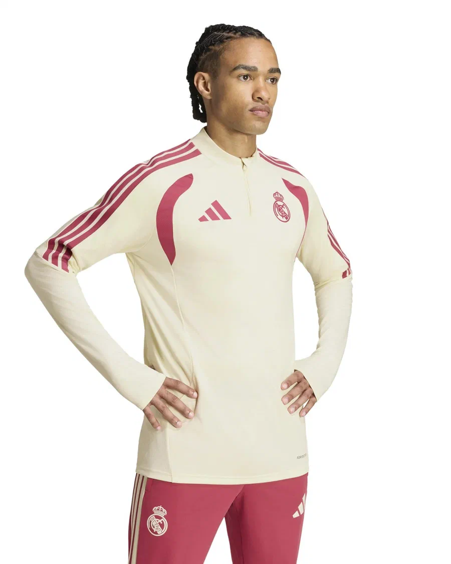 Mannequin en sweat zippé ivoire à bandes framboise et pantalon framboise du Real Madrid, mains sur les hanches